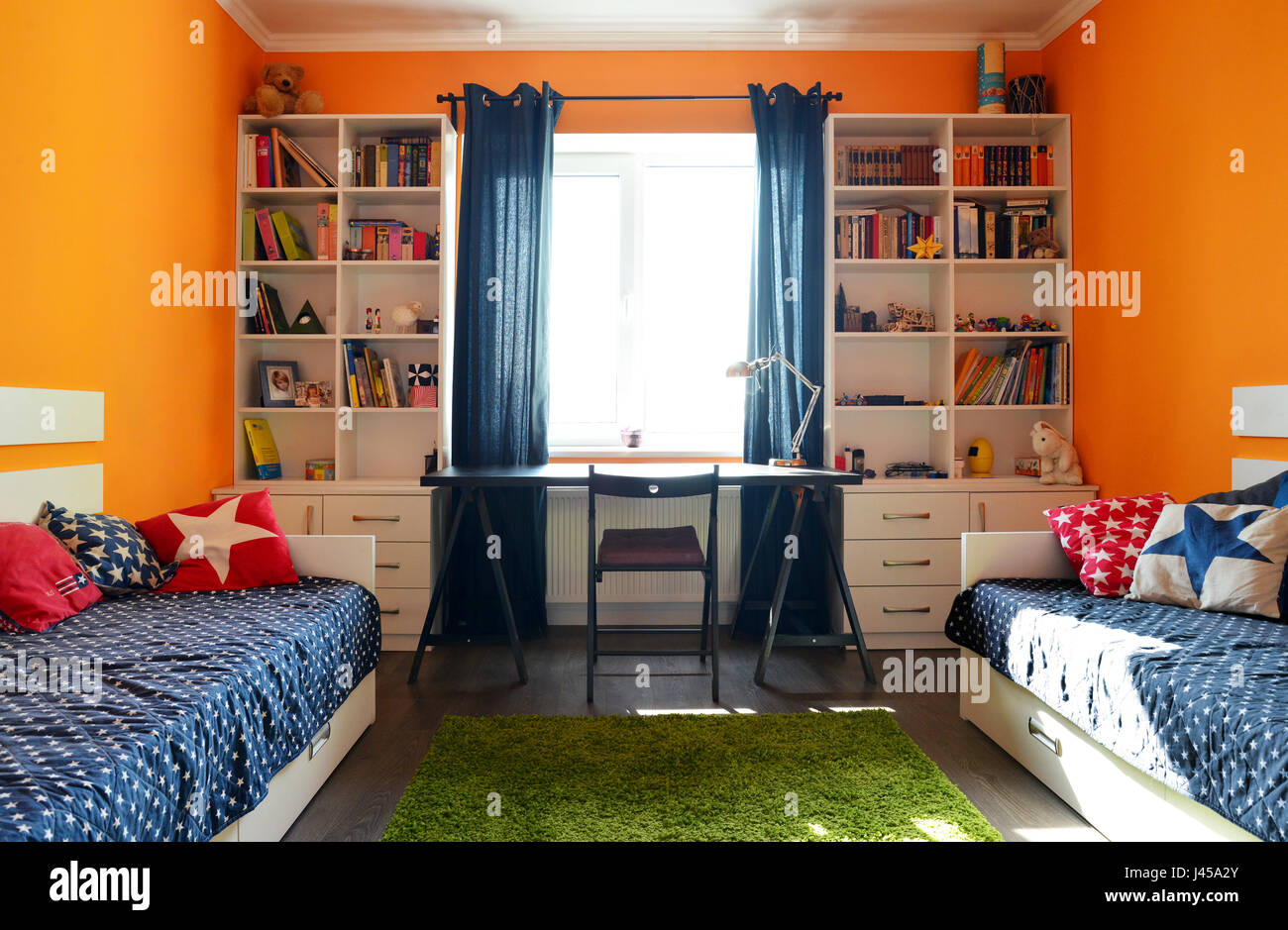 Kids Bedroom In Orange And Blue Colors With Two Beds And Bookcases Stock Photo Alamy