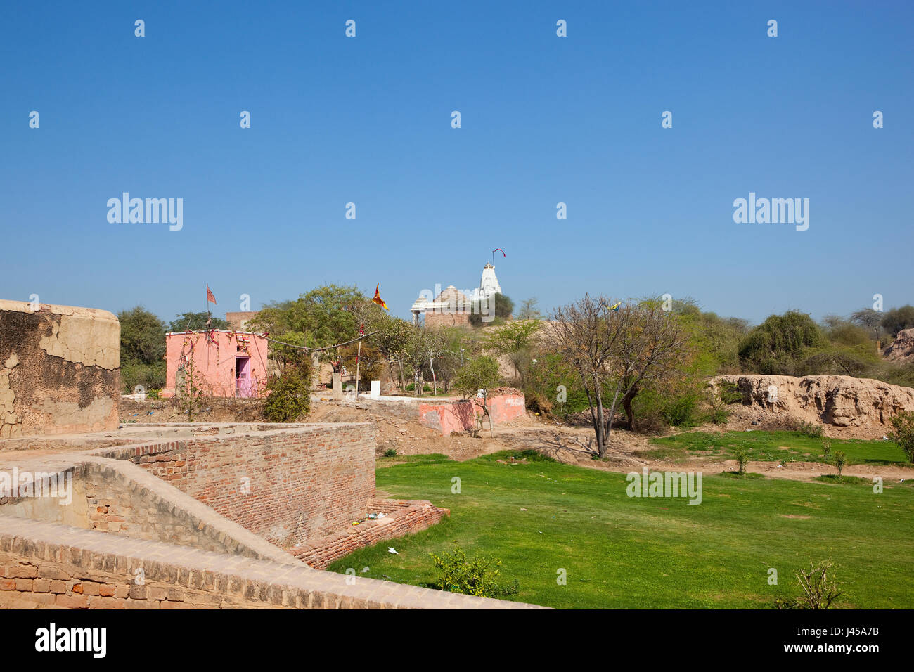 the top of bhatner fort with a hindu temple and grounds currently under restoration work in the city of hanumangarh rajasthan india under a blue sky i Stock Photo