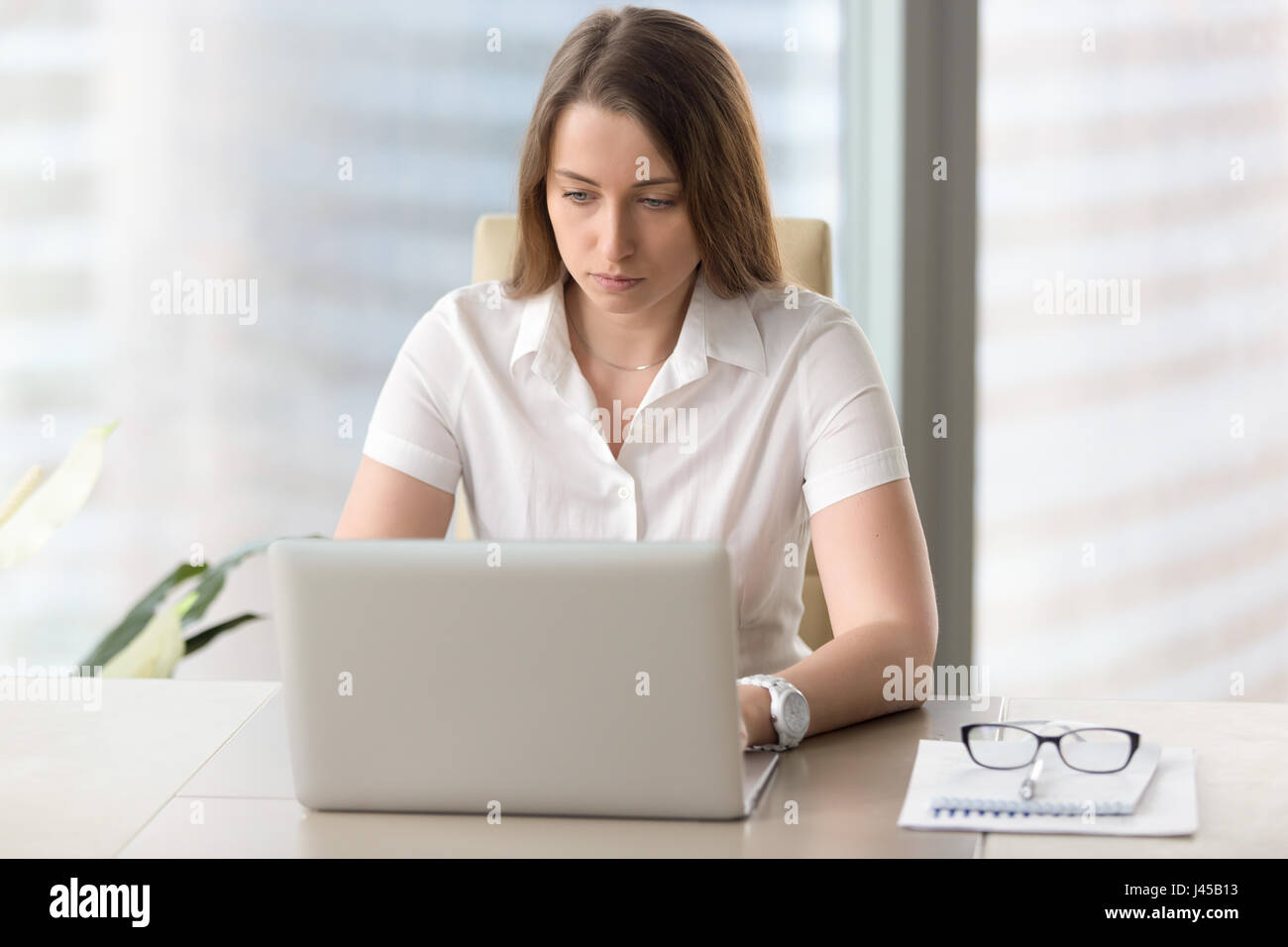 Young businesswoman concentrated on daily tasks Stock Photo