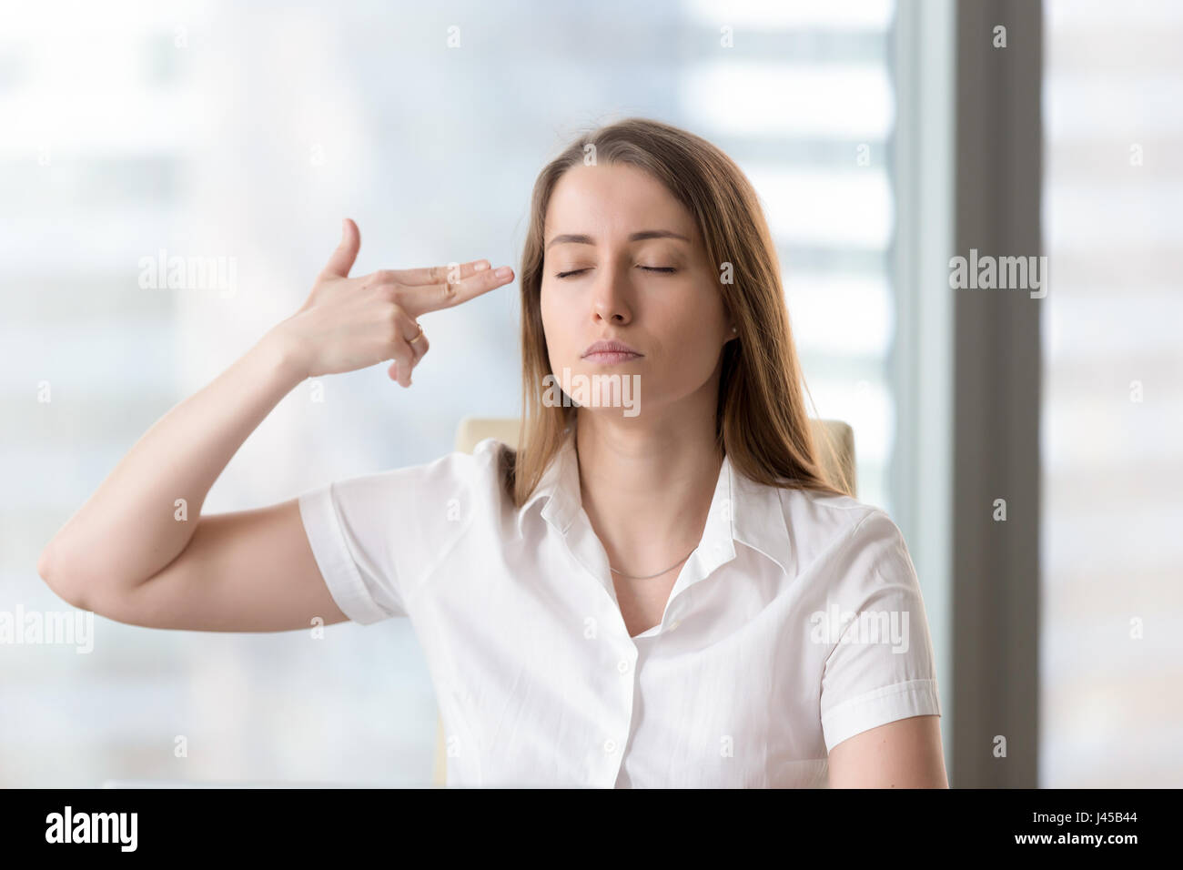 Businesswoman makes suicide with gun from fingers Stock Photo