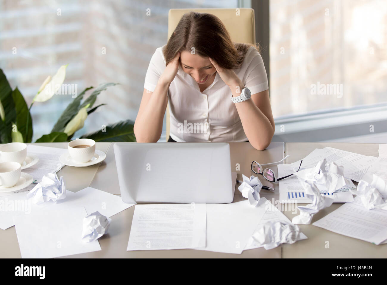 Businesswoman goes mad because of missing deadline Stock Photo