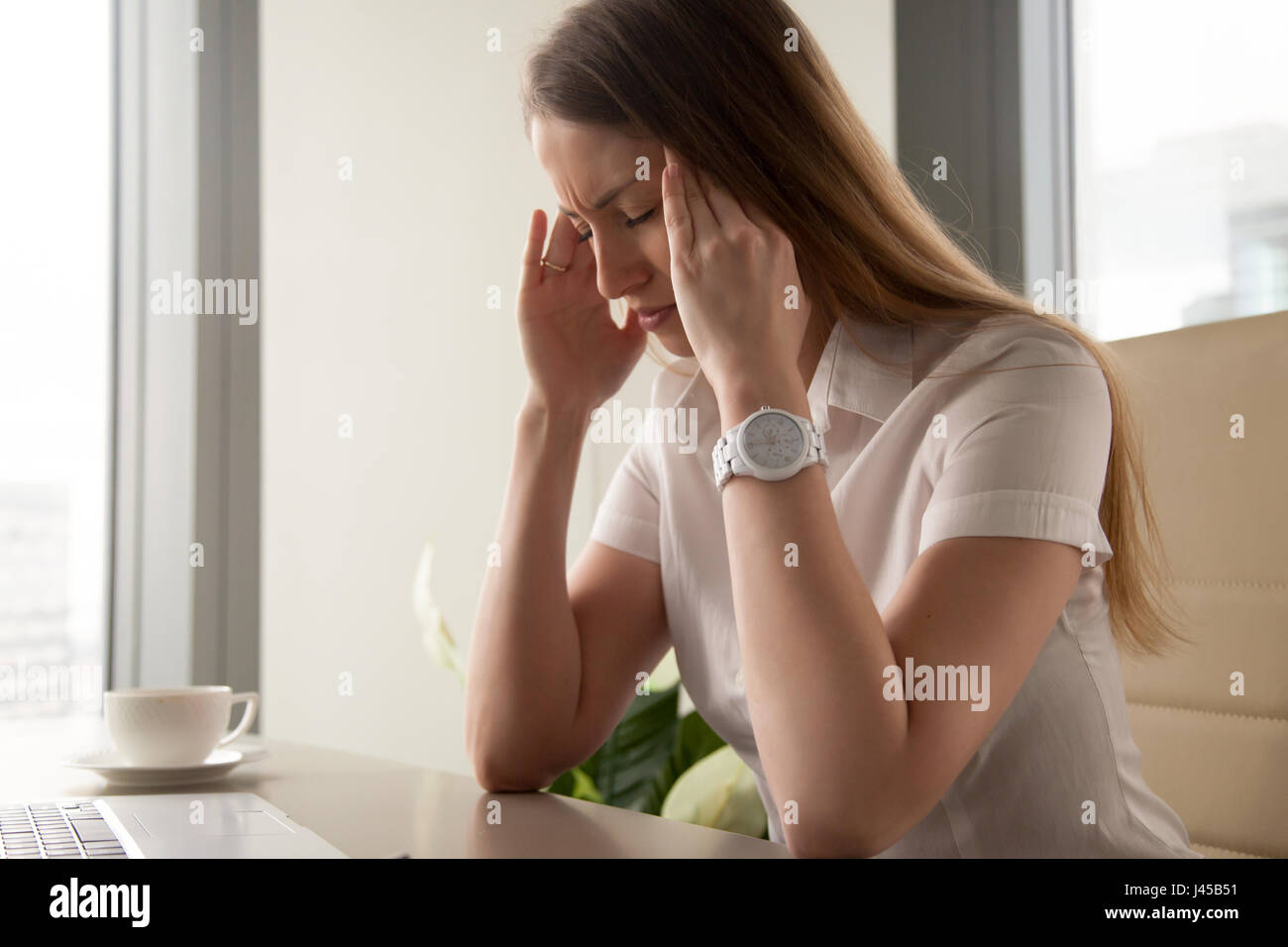 Businesswoman tries to cope with nervous tension Stock Photo