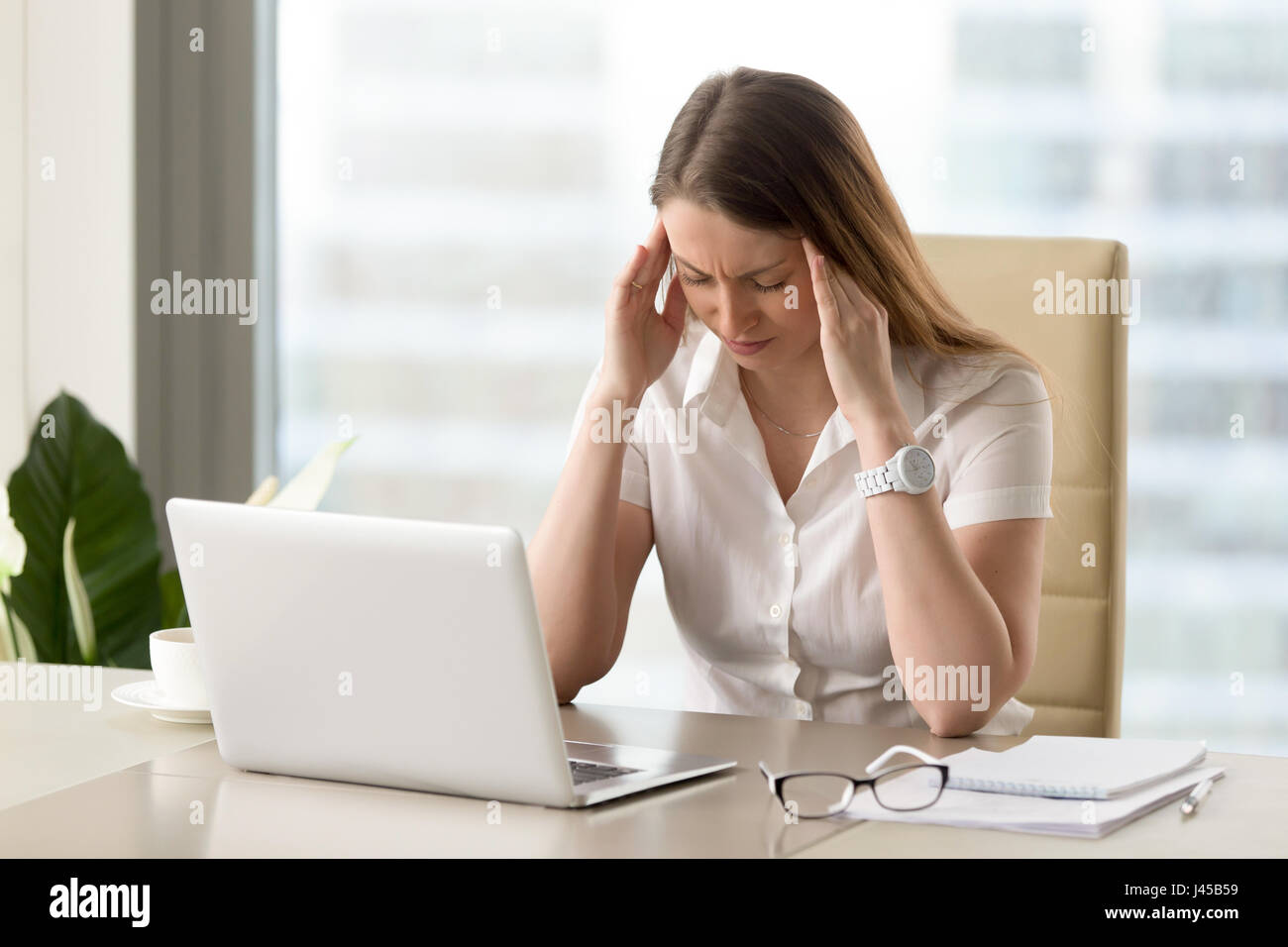Businesswoman under physical tension at work Stock Photo