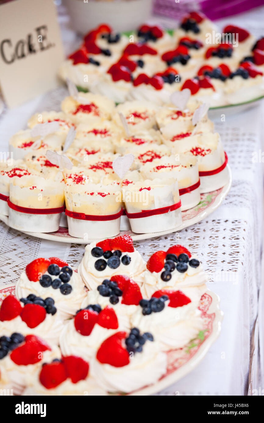 cupcakes with whipped cream and berries on plates Stock Photo