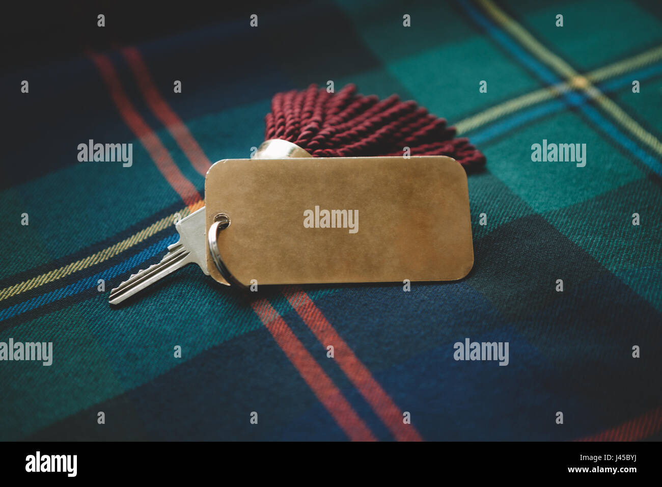 Tassel key tag on tartan kilt background Stock Photo
