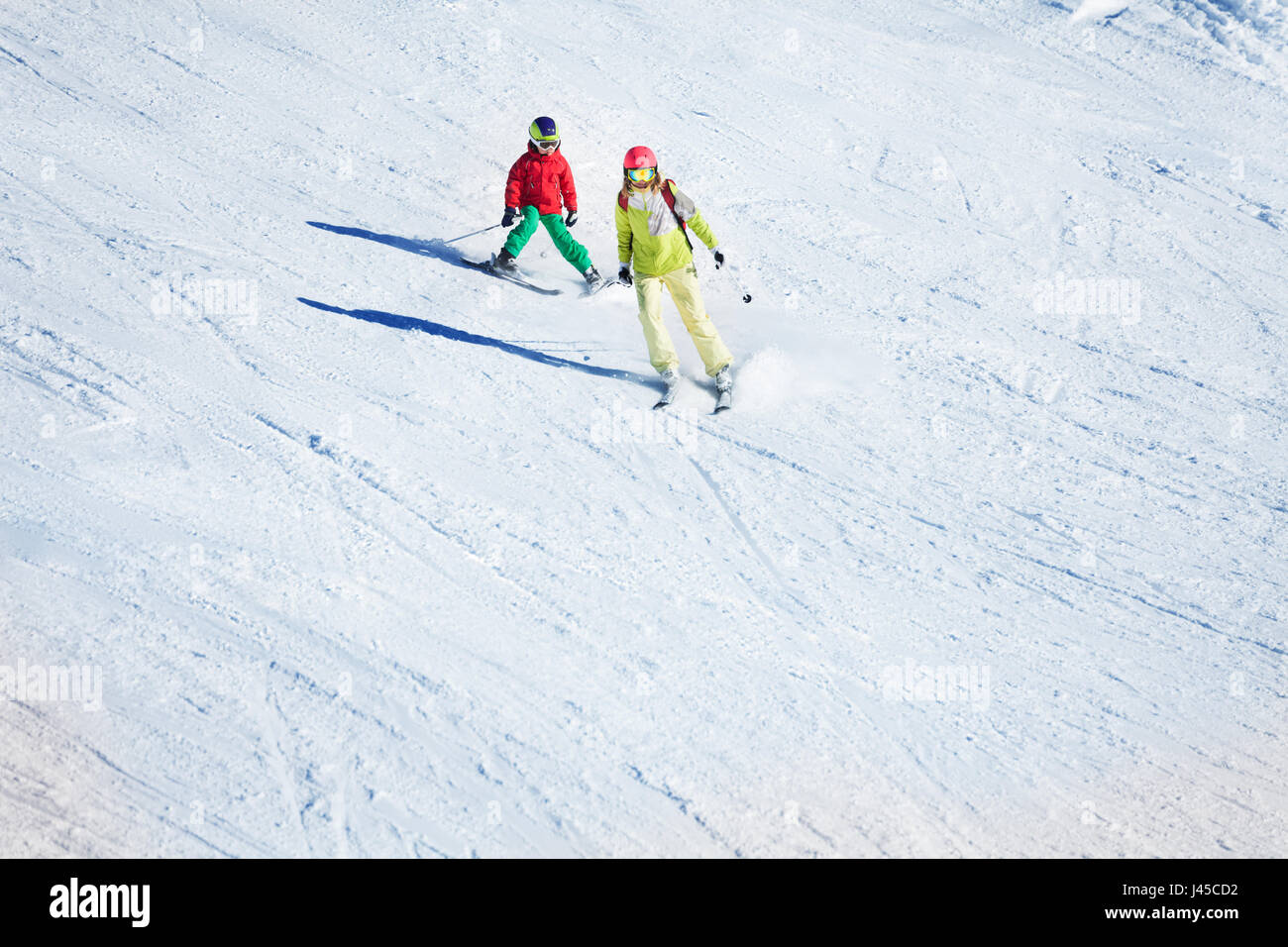 Two skiers hitting the slopes at snowy mountains Stock Photo
