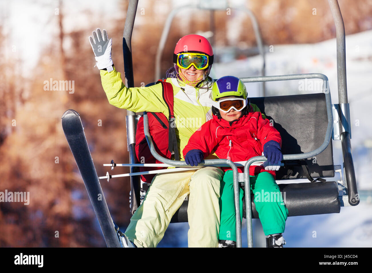 Happy skiers lifting on chairlift at mountains Stock Photo