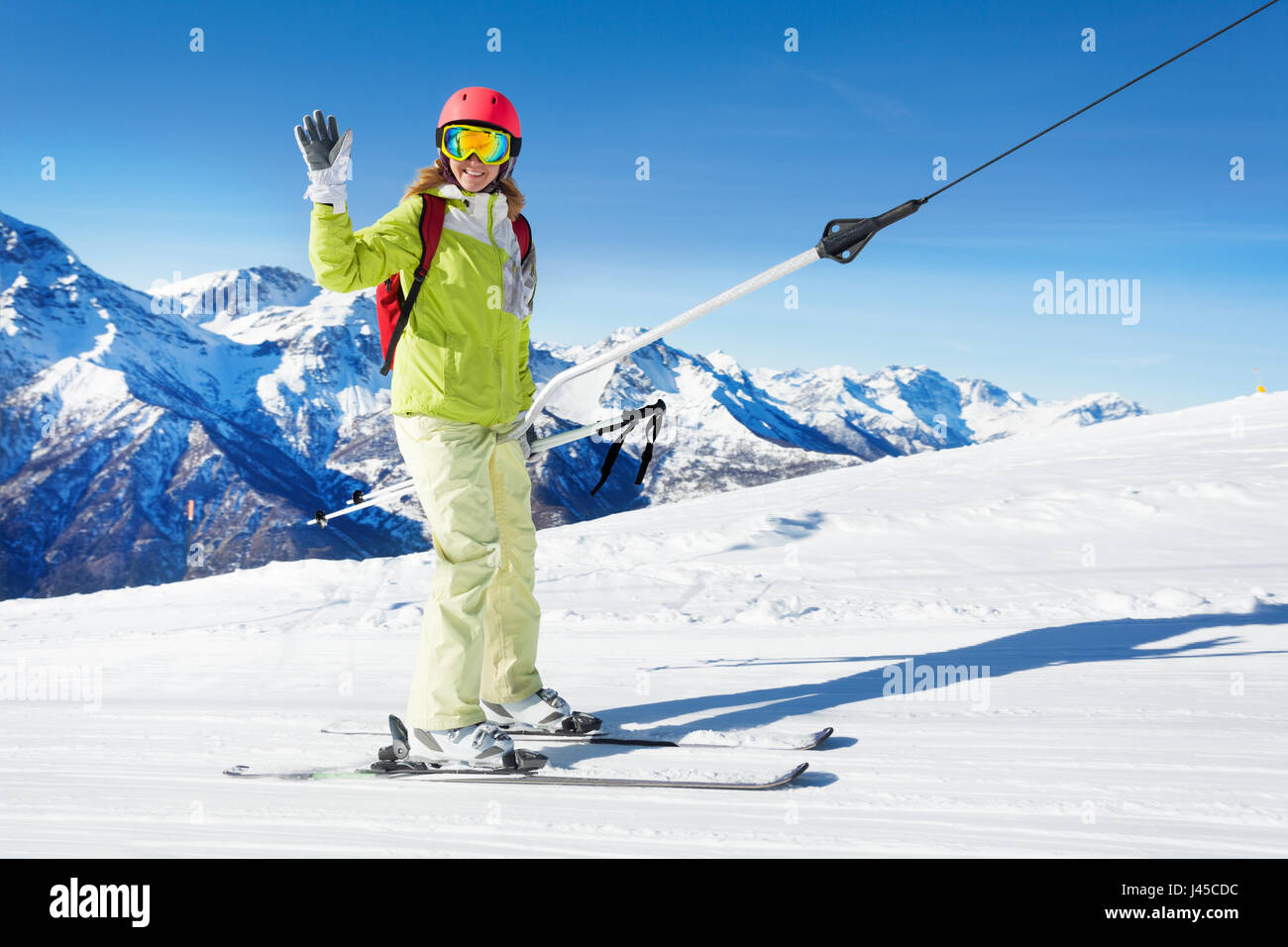 Girl on button ski lift going uphill, waving hand Stock Photo Alamy
