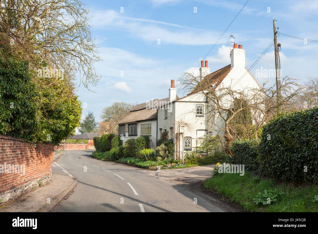 Country lane and house in the rural village of Cropwell Butler, Nottinghamshire, England, UK Stock Photo
