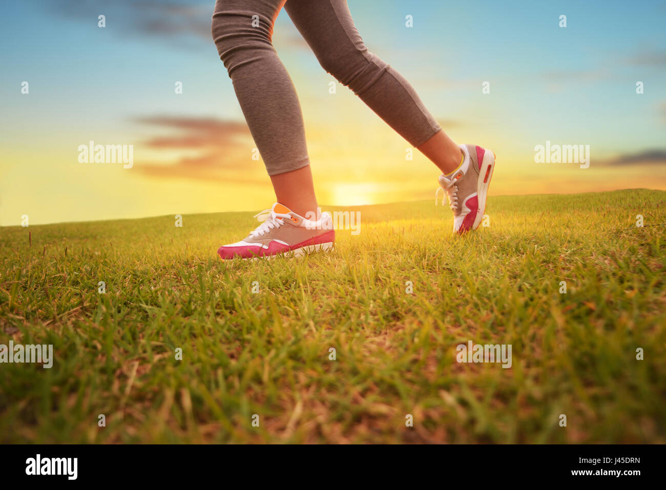 Side view of a girl running legs and feet. Sun lawn Stock Photo Alamy