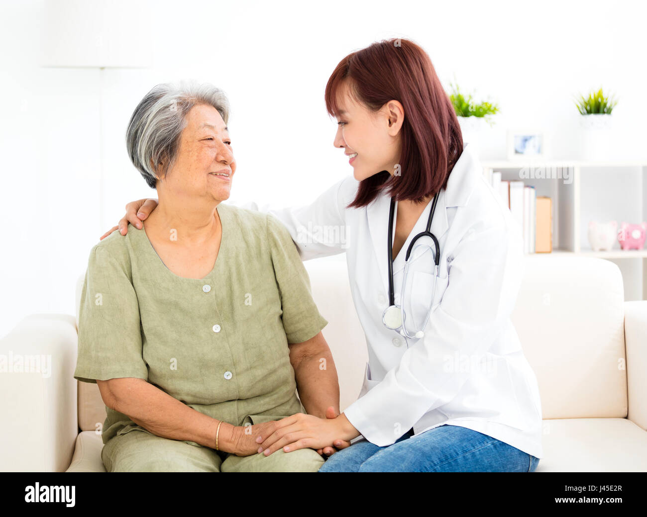 young smiling home caregiver  with senior woman Stock Photo