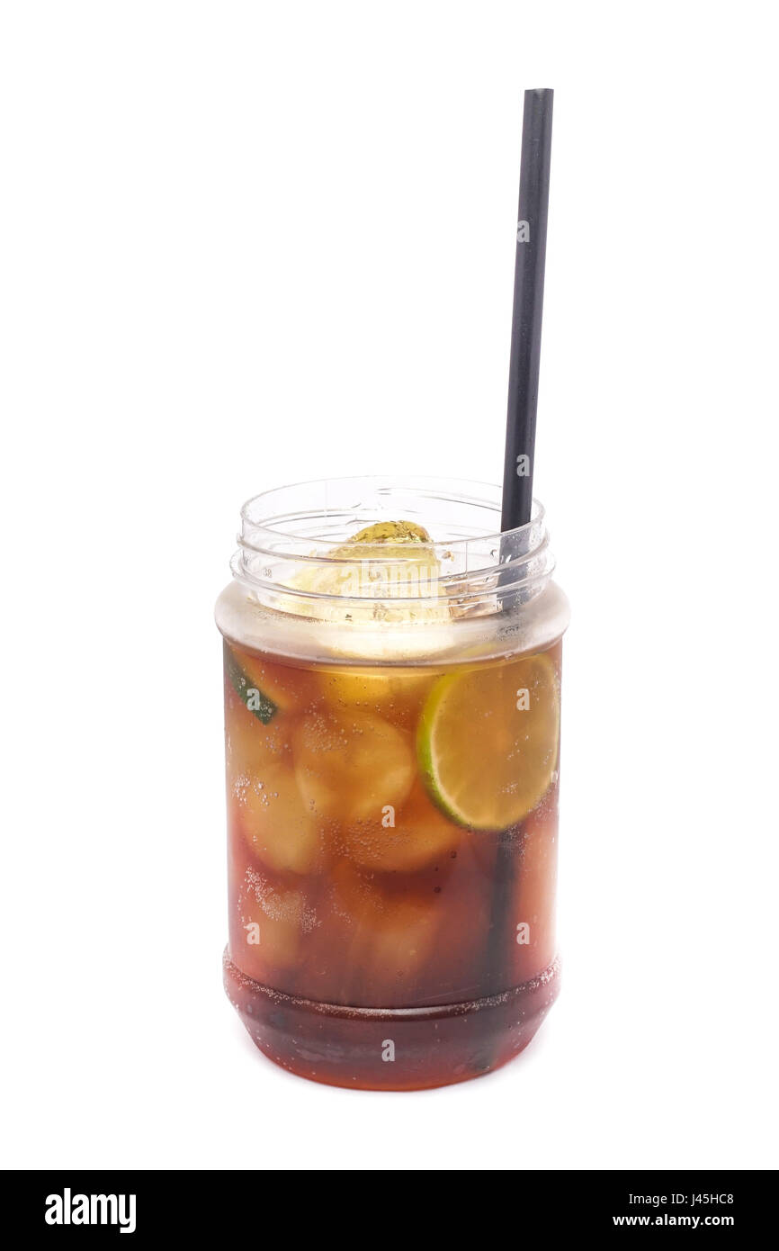 Close up of glass with alcohol cocktail with lime, vodka and cola isolated on a white background. Stock Photo