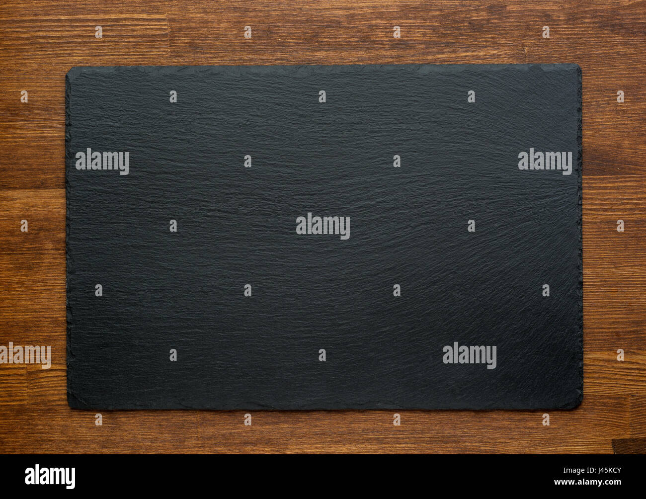 Black slate stone on wooden background, top view Stock Photo