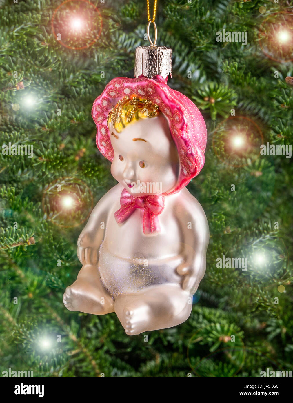 Christmas bauble hanging from a tree in the shape of a Cute Baby Stock Photo