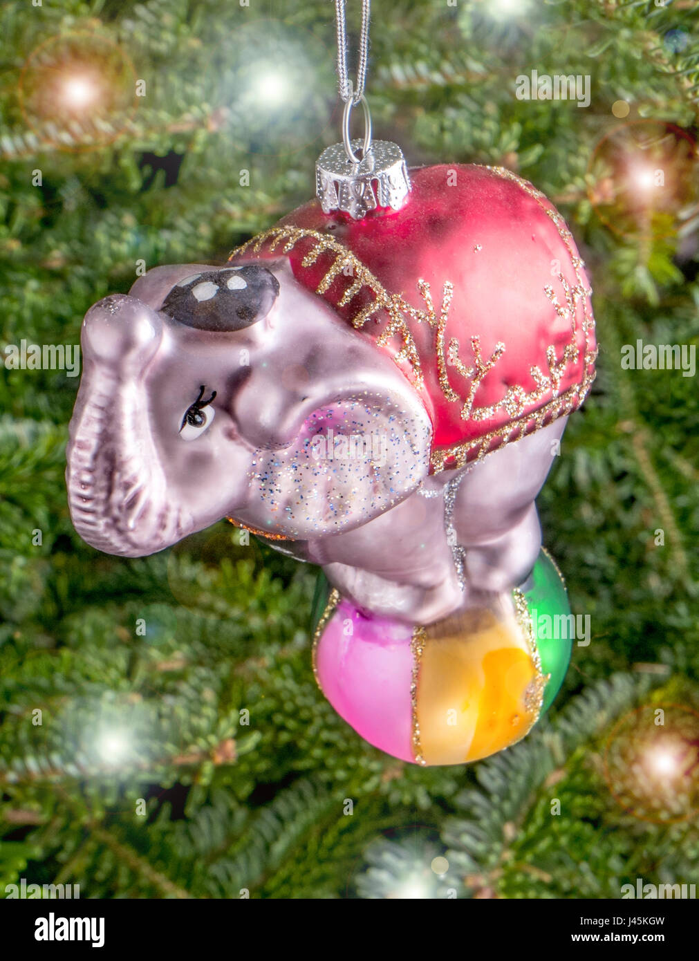 Christmas bauble hanging from a tree in the shape of a Circus Elephant balancing on a Ball Stock Photo
