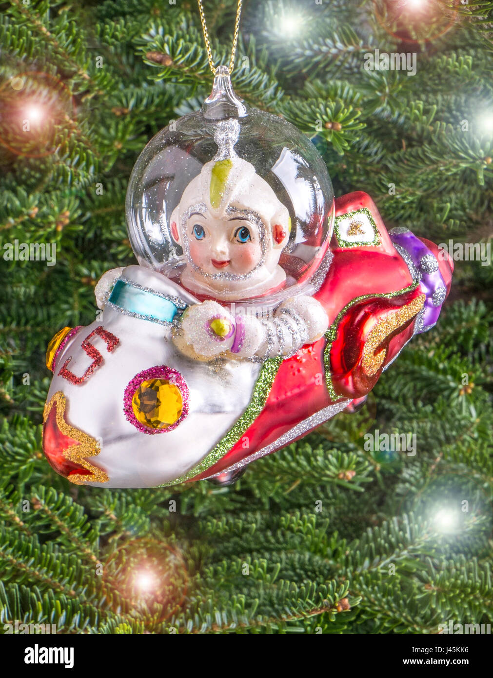 Christmas bauble hanging from a tree in the shape of a 50's Space Rocket Stock Photo