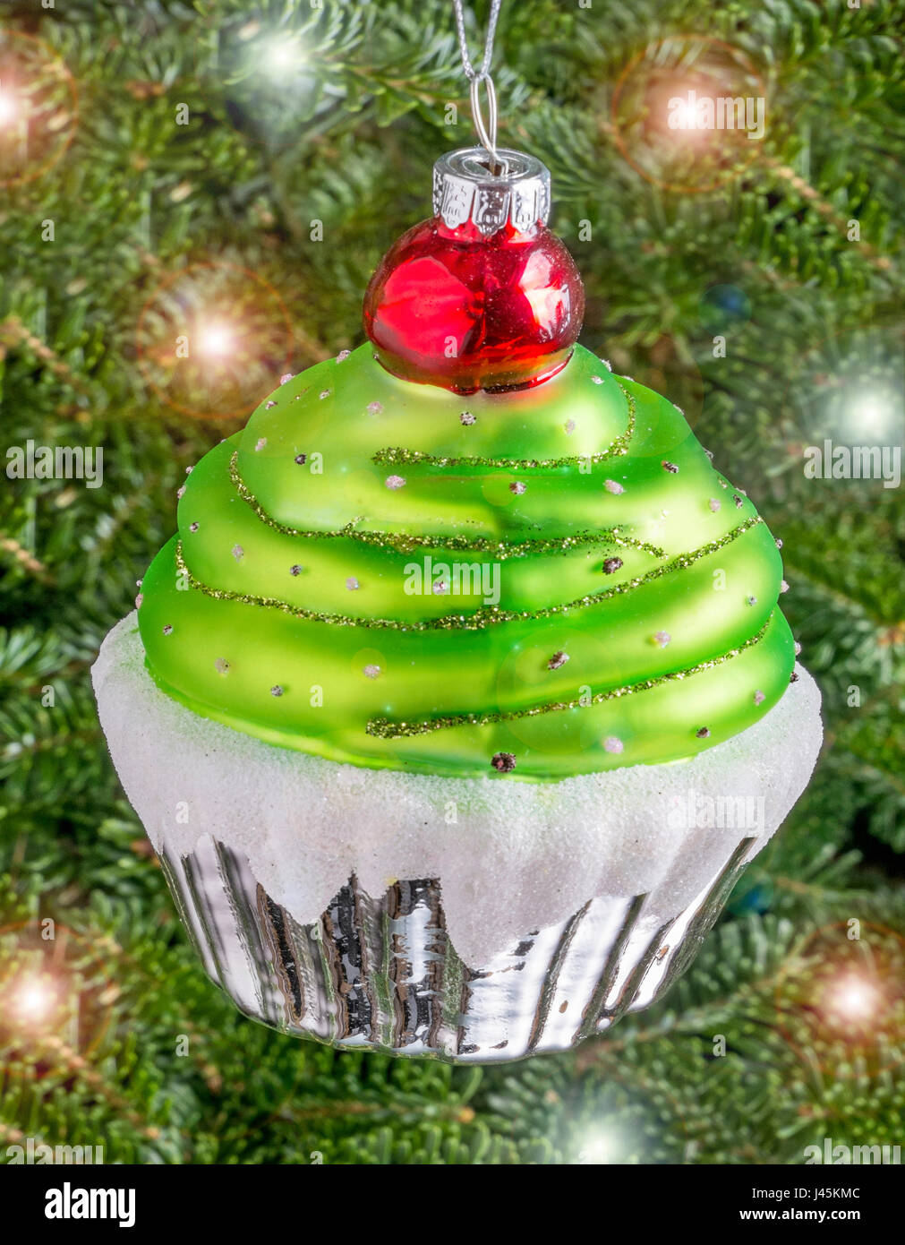 Christmas bauble hanging from a tree in the shape of a Cup Cake Stock Photo