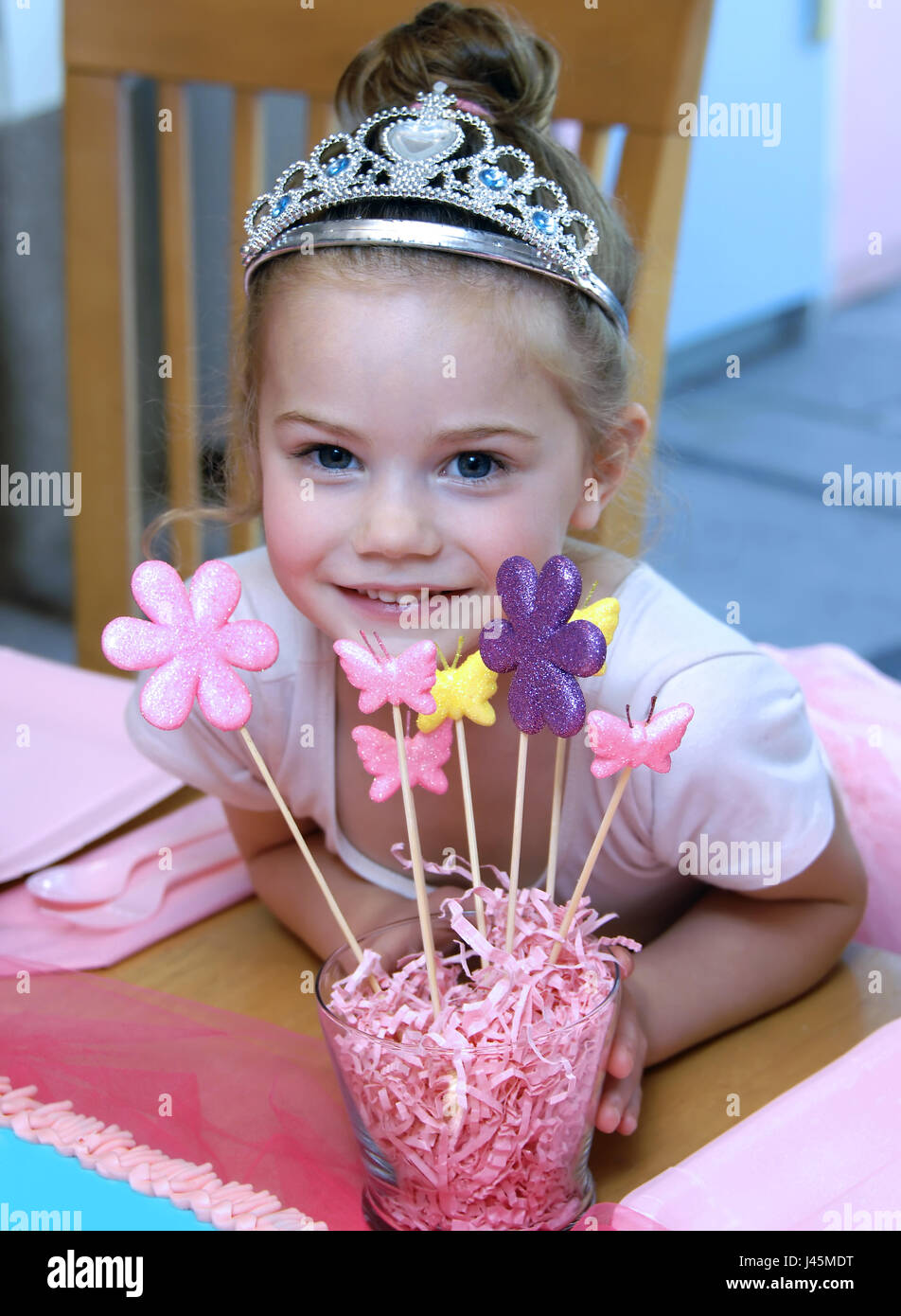 Little girl has ballerina birthday party. She poses besides her