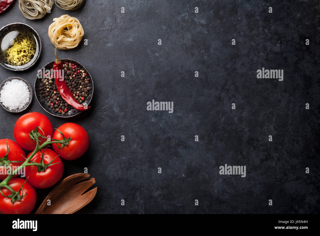 Cooking ingredients and utensils on stone table. Top view with space ...