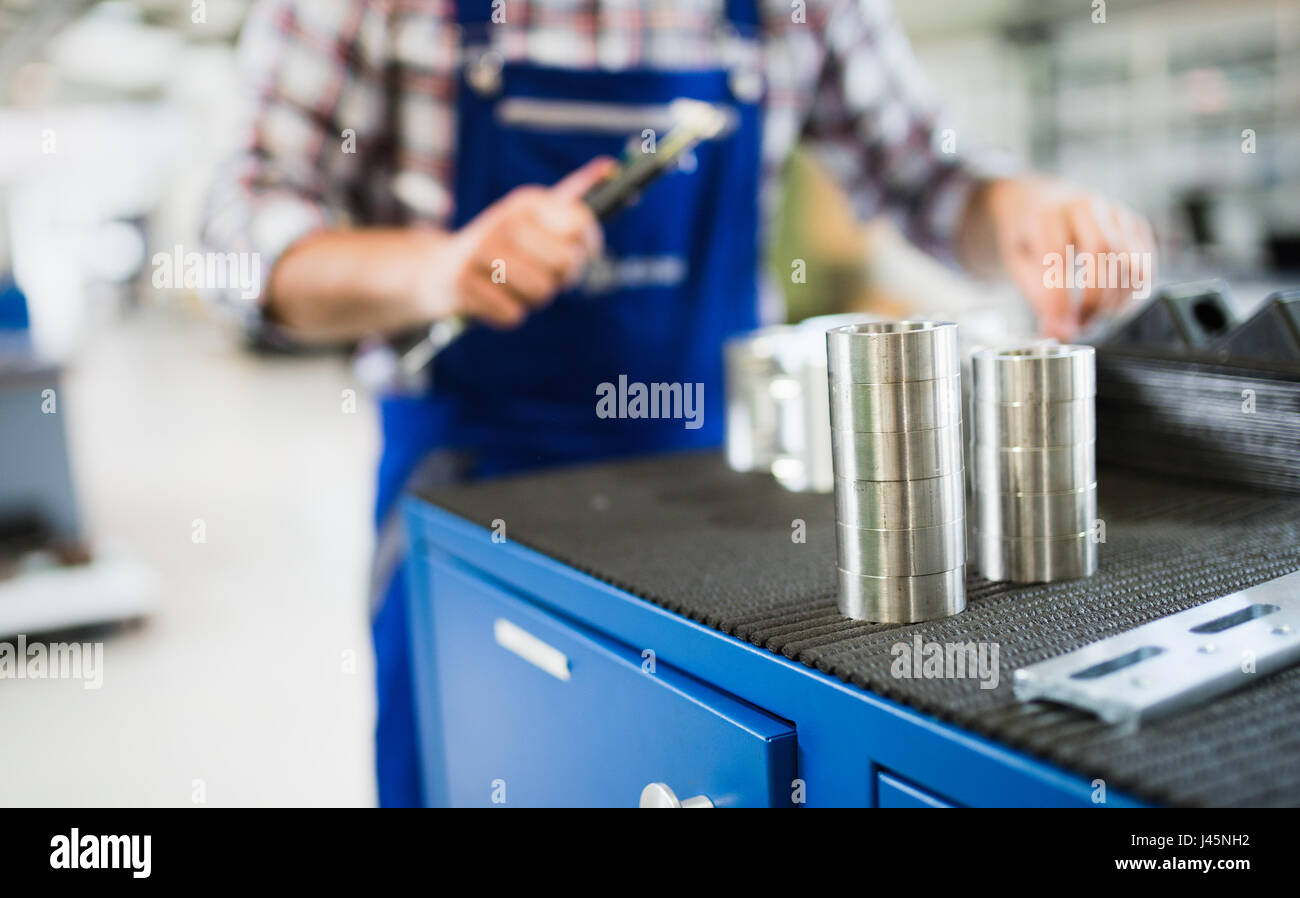 Bearings in metal industry factory with worker in background Stock Photo