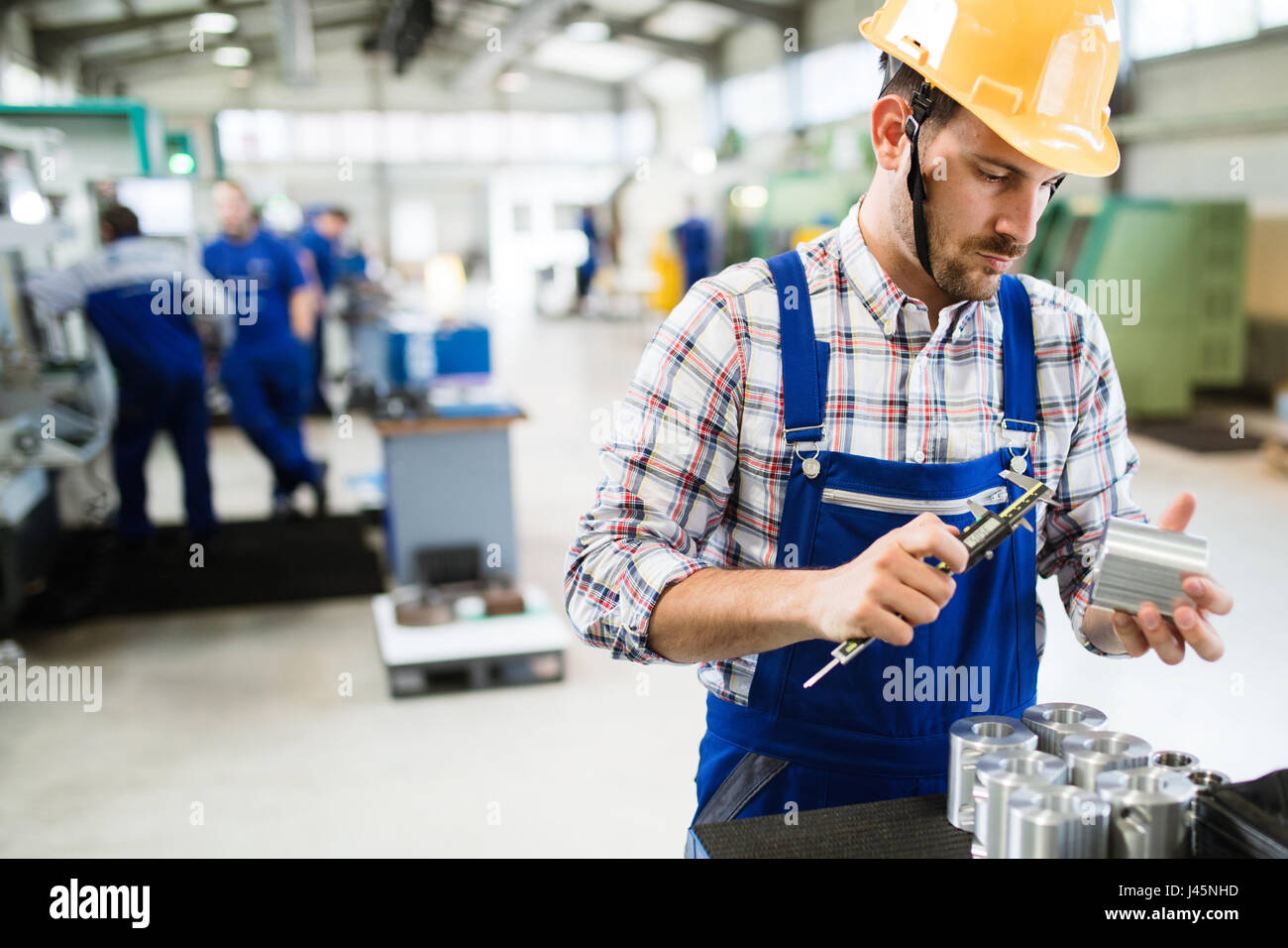 Male worker and quality control inspection in metal industry factory