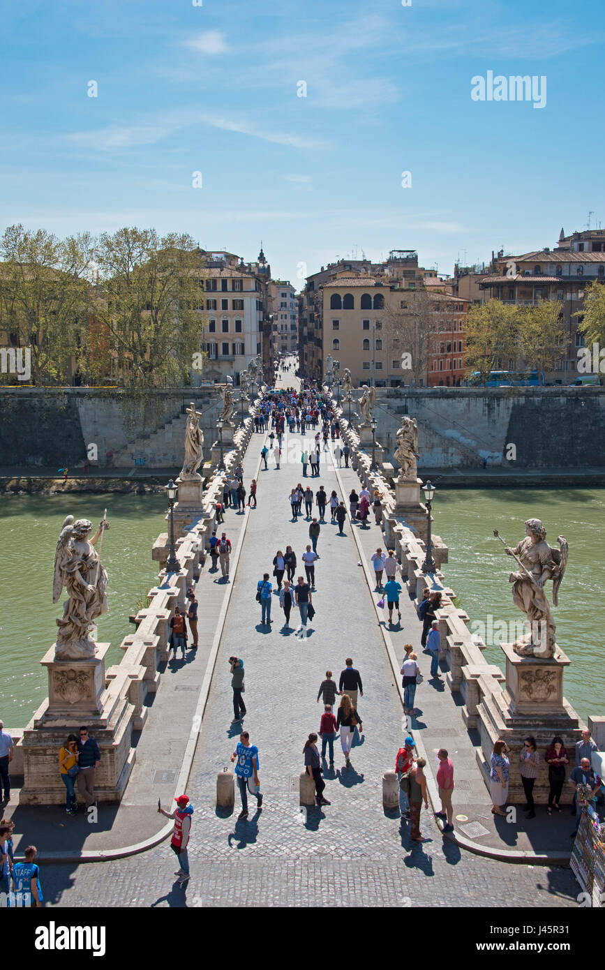 The Castel Sant'Angelo with the tourists walking across the pedestrian St. Angelo Bridge or Ponte Sant'Angelo across the River Tiber on a sunny day. Stock Photo