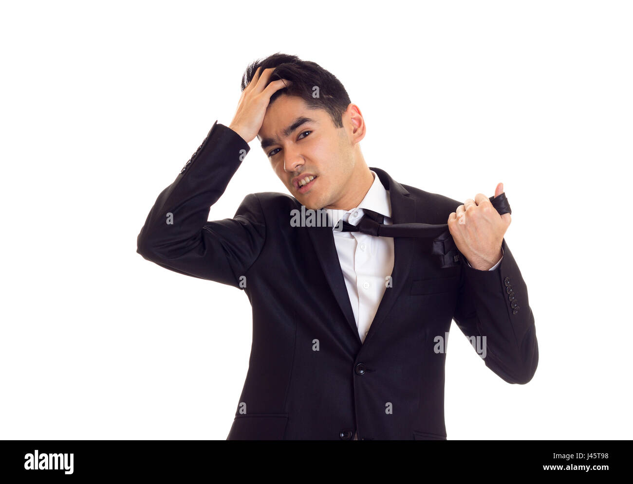 Young man in suit fixing his tie Stock Photo - Alamy