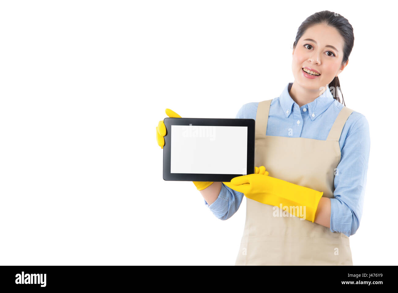 happy domestic clean lady smile displaying digital touch pad computer to promotion home cleaning services on blank tablet on internet. isolated on whi Stock Photo
