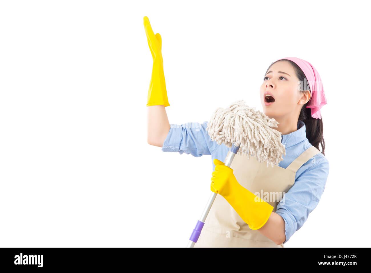 Mixed race Asian female cleaning woman having fun during spring cleaning. Funny woman cleaning wearing rubber gloves singing into broom. isolated on w Stock Photo