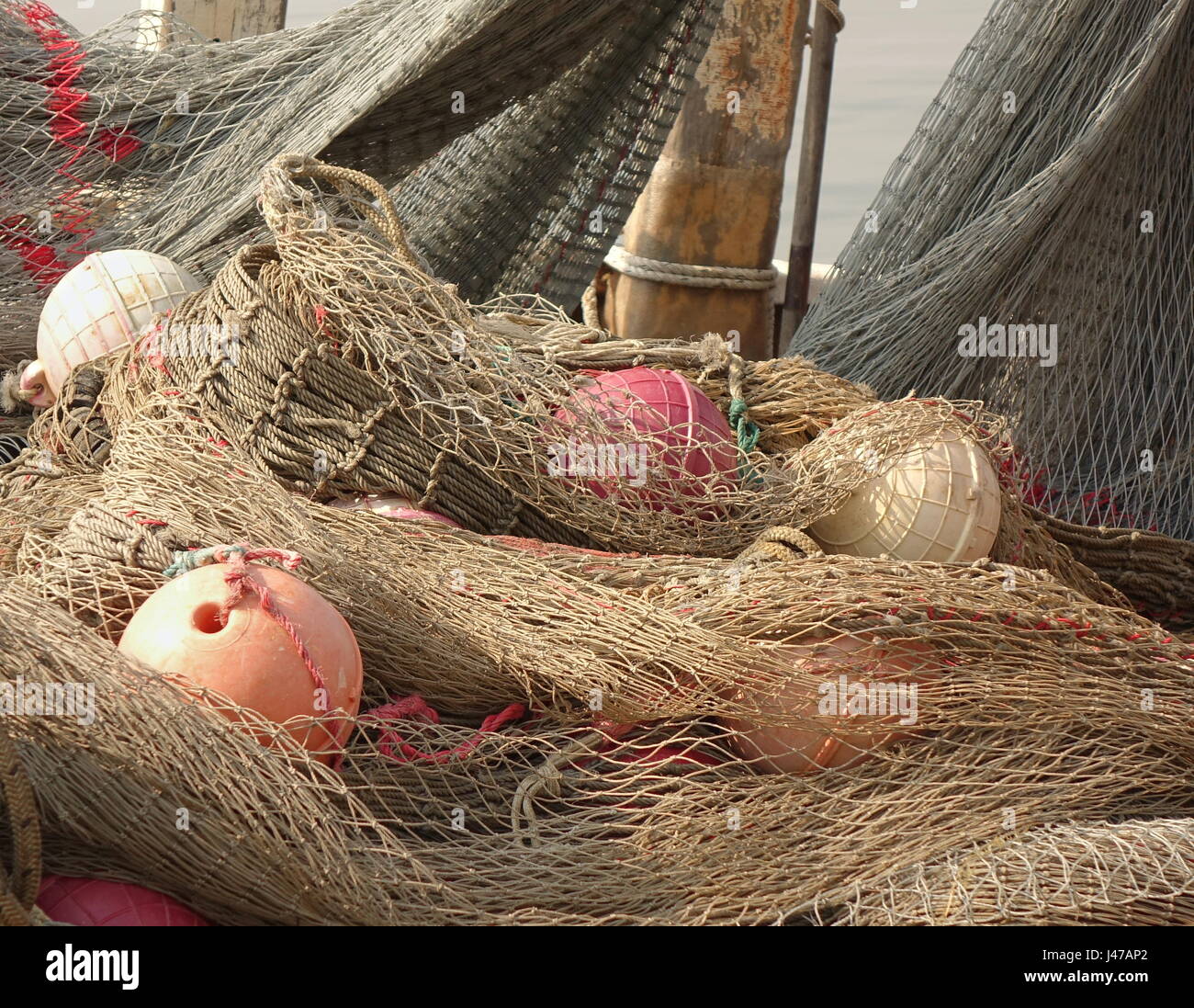 https://c8.alamy.com/comp/J47AP2/a-pile-of-old-fishing-nets-with-hollow-round-plastic-floats-J47AP2.jpg
