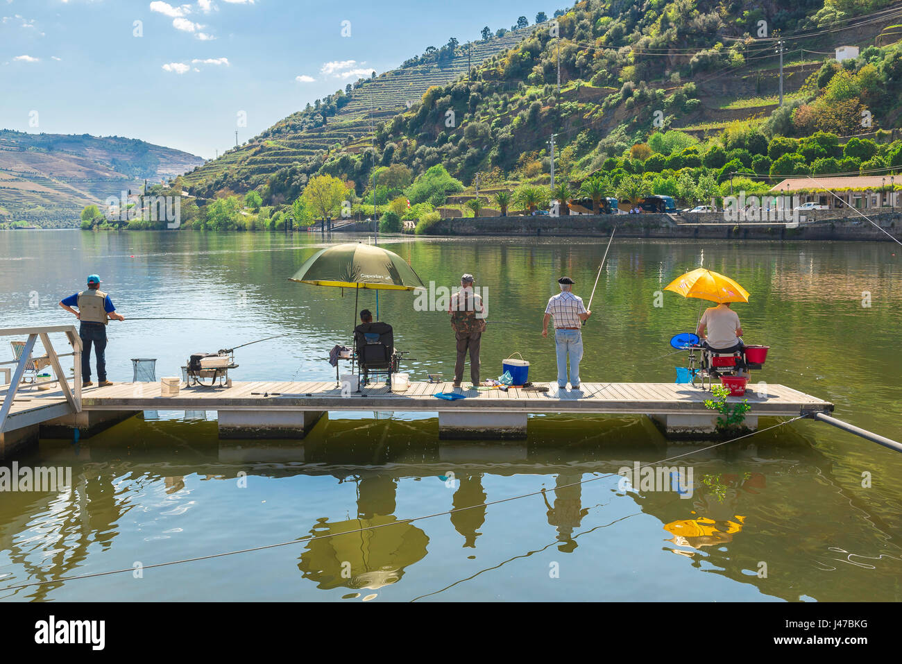 Douro Valley Portugal, men fishing the Douro River from a jetty in the port wine town of Pinhao, Portugal Stock Photo