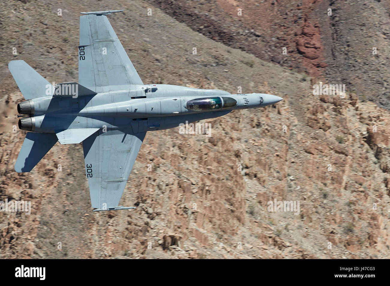 United States Navy F/A-18C, Hornet, Flying At High Speed And Low Level, Through A Desert Canyon. Stock Photo