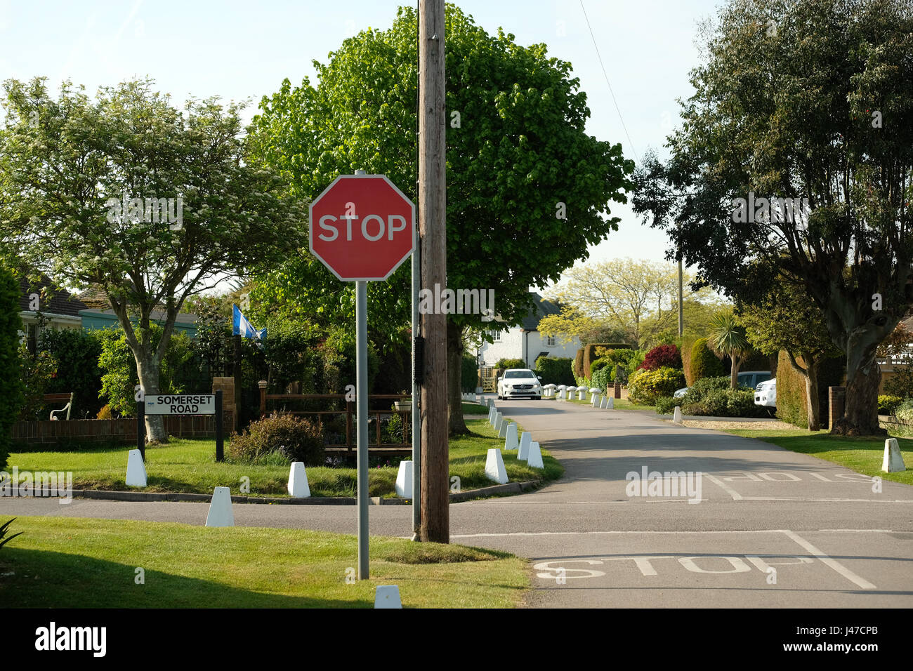Red and white stop sign warning motorists and cyclists to stop on a cross roads with hidden dangers. Stock Photo