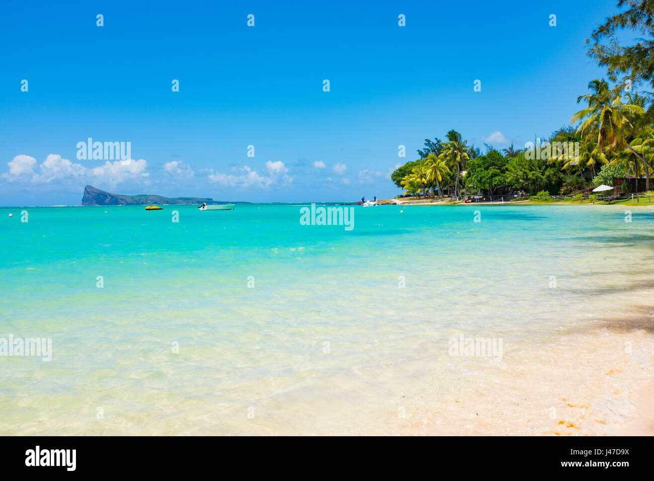 Beach on the tropical island. Clear blue water, sand and palm trees. Beautiful vacation spot, treatment and aquatics. Stock Photo