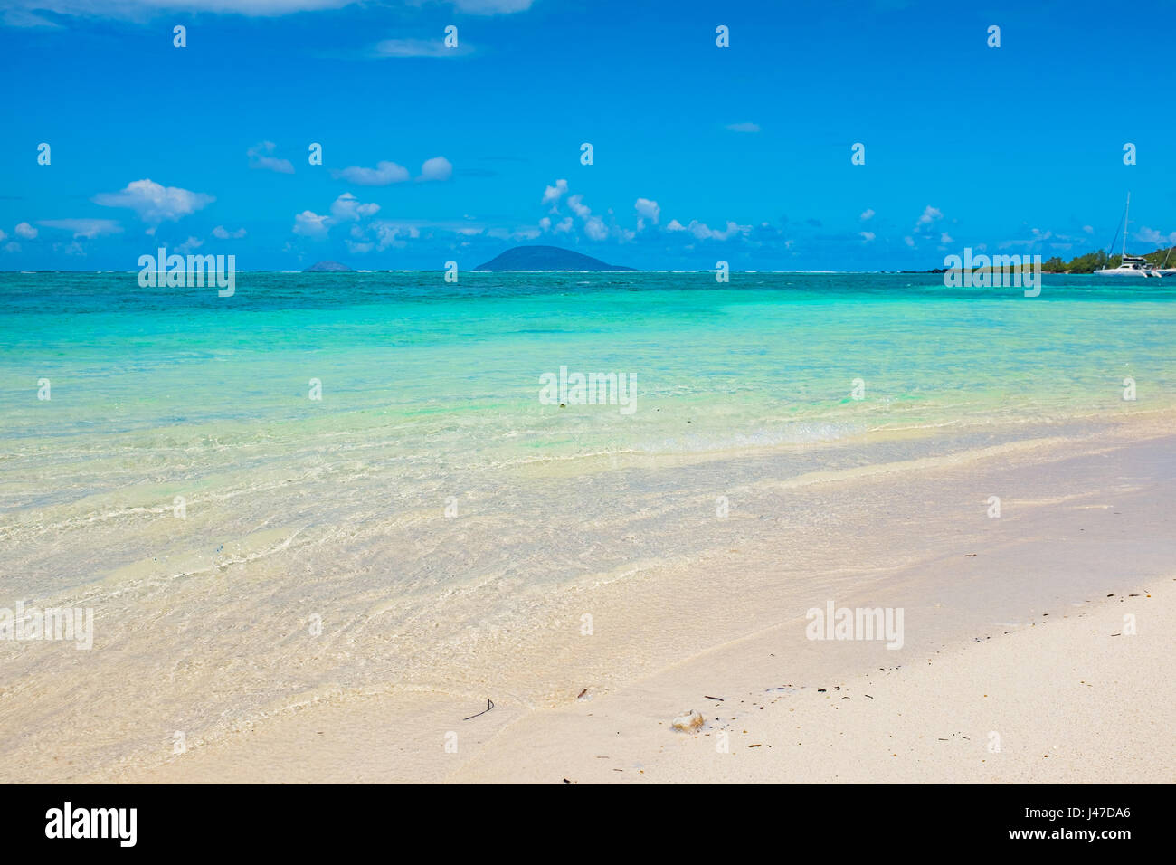 Beach on the tropical island. Clear blue water, sand and palm trees. Beautiful vacation spot, treatment and aquatics. Stock Photo