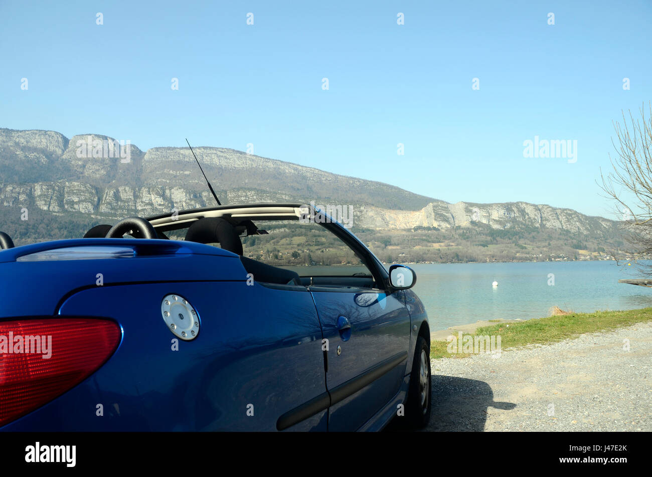 Convertible car and Annecy lake blue convertible car along Annecy