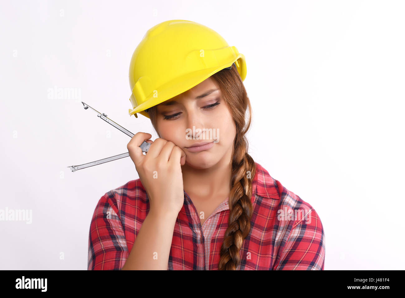 Close up of beautiful woman construction worker thinking with compass and construction helmet. Isolated white background. Stock Photo