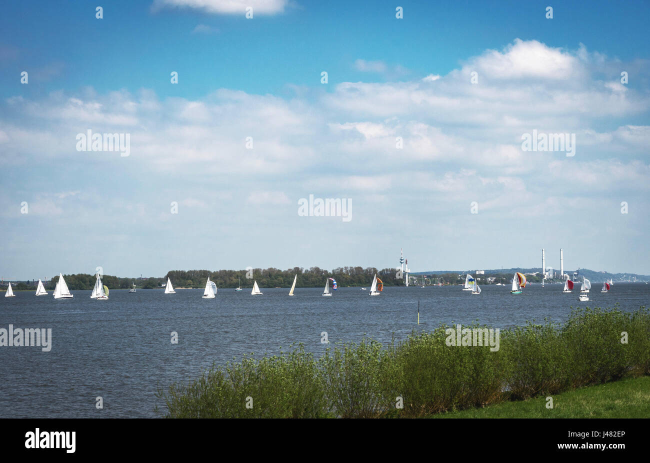 Weekend and beautiful windy weather: Sailing boats on the river Elbe at the dike in Lühe (Altes Land) near Hamburg, Germany Stock Photo