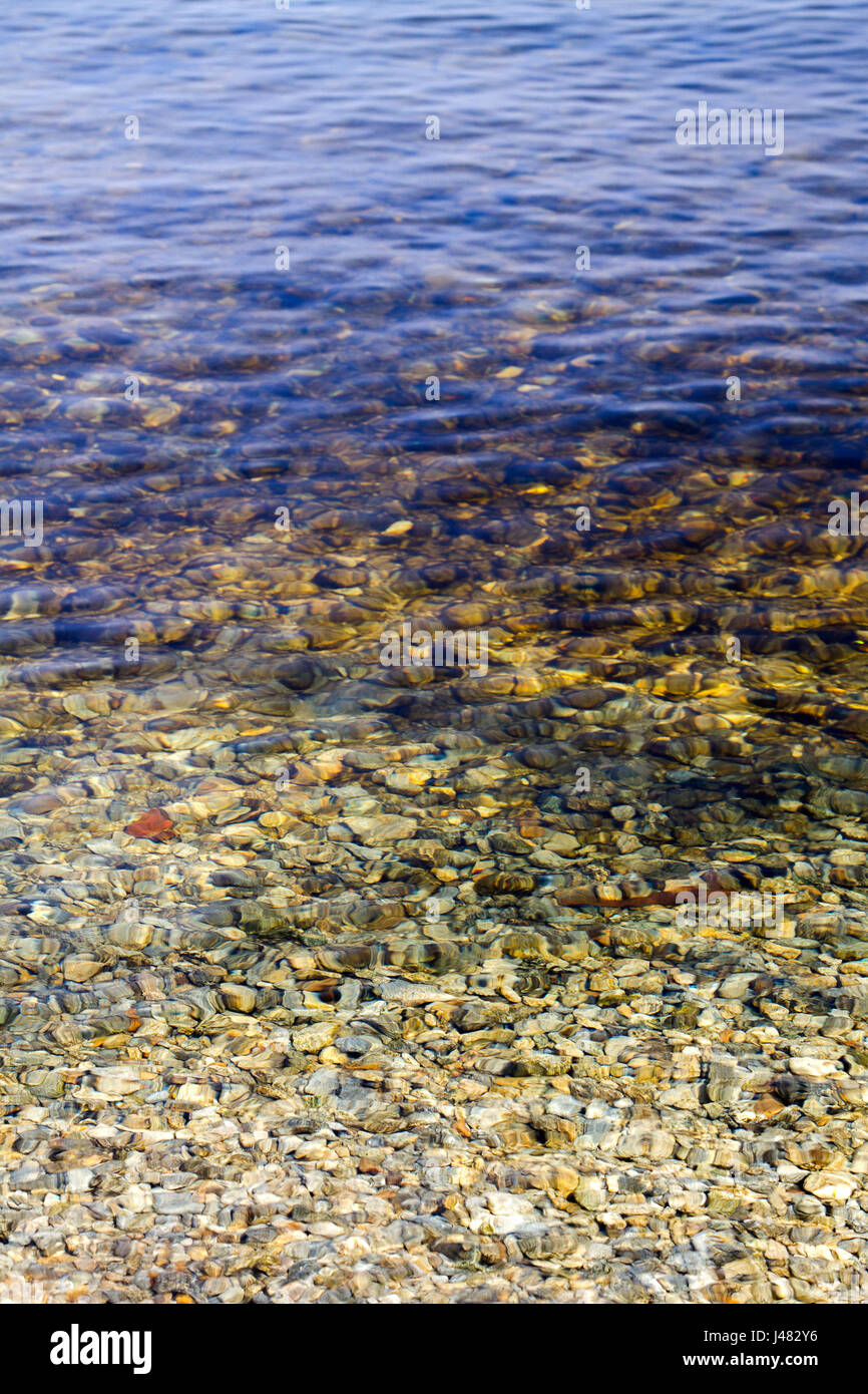 a Preview of clear water near the shore with pebbles at the bottom ...