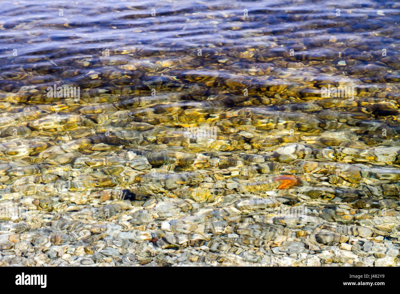 a Preview of clear water near the shore with pebbles at the bottom ...