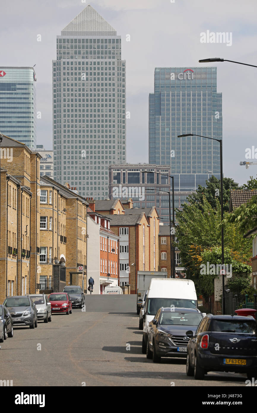 View along Rotherhithe Street in Southeast London, a residential street with the towers of Canary Wharf in the background. Shows cyclist in distance. Stock Photo