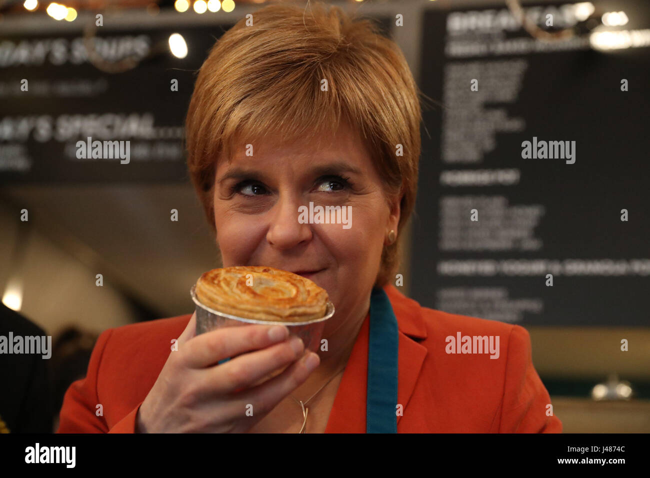 SNP Leader Nicola Sturgeon savours the aroma of a haggis pie featuring the party's logo that she helped to make on a campaign visit to Table 13 Express in Kirkintilloch, East Dunbartonshire. Stock Photo