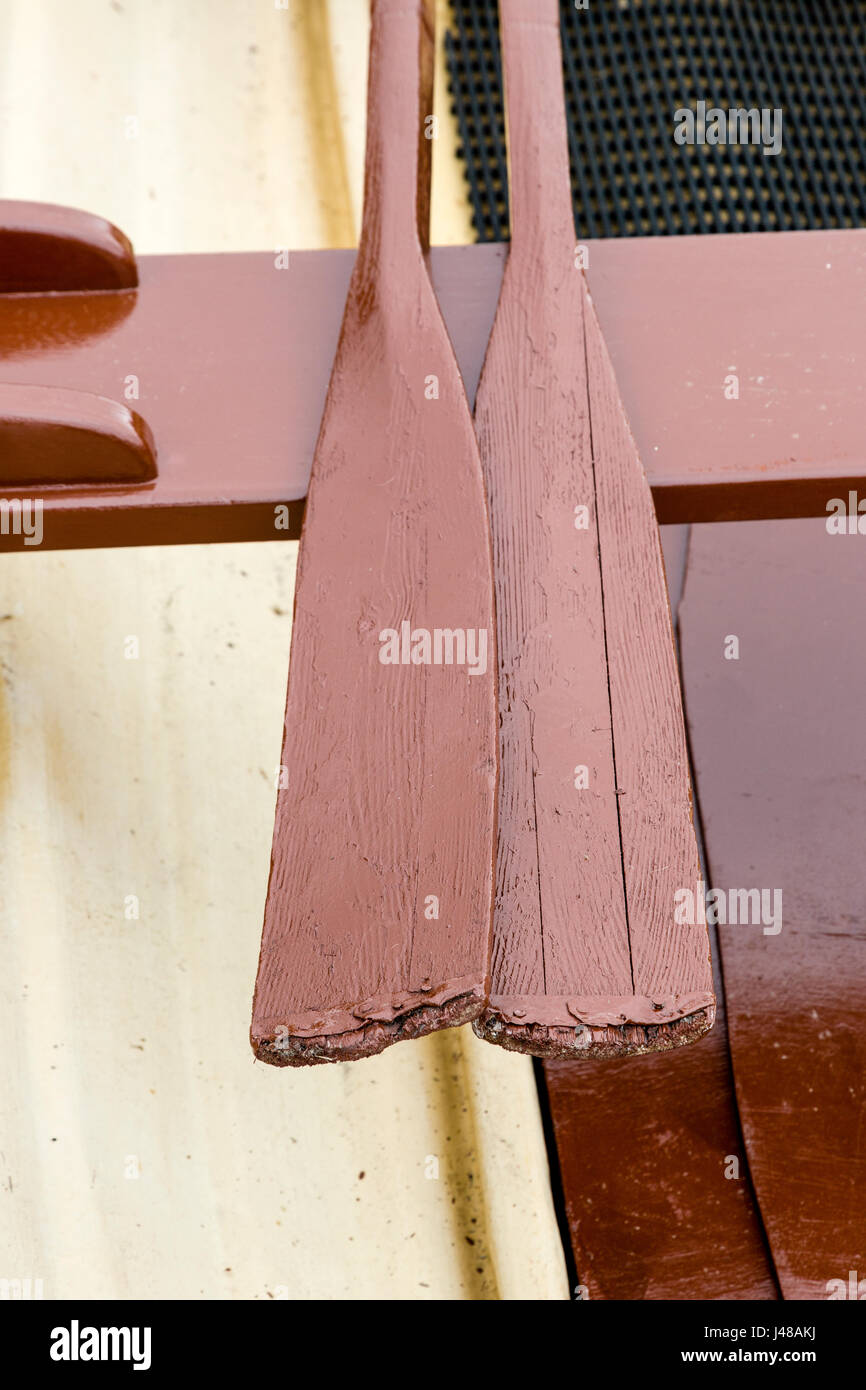 Brown painted wood rowing boat oars on seat Stock Photo