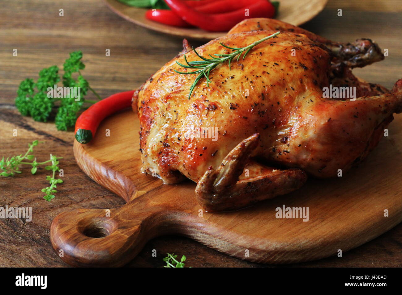 Whole roasted chicken on cutting board Stock Photo
