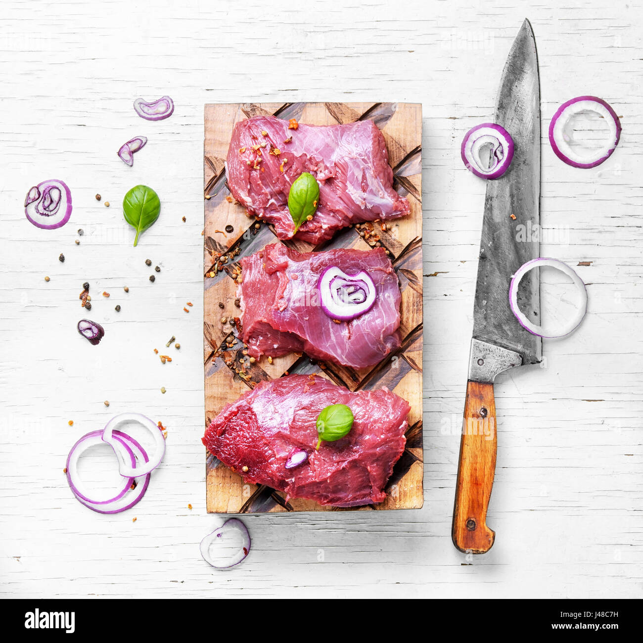 Raw beef meat on cutting board with spices and onion Stock Photo - Alamy