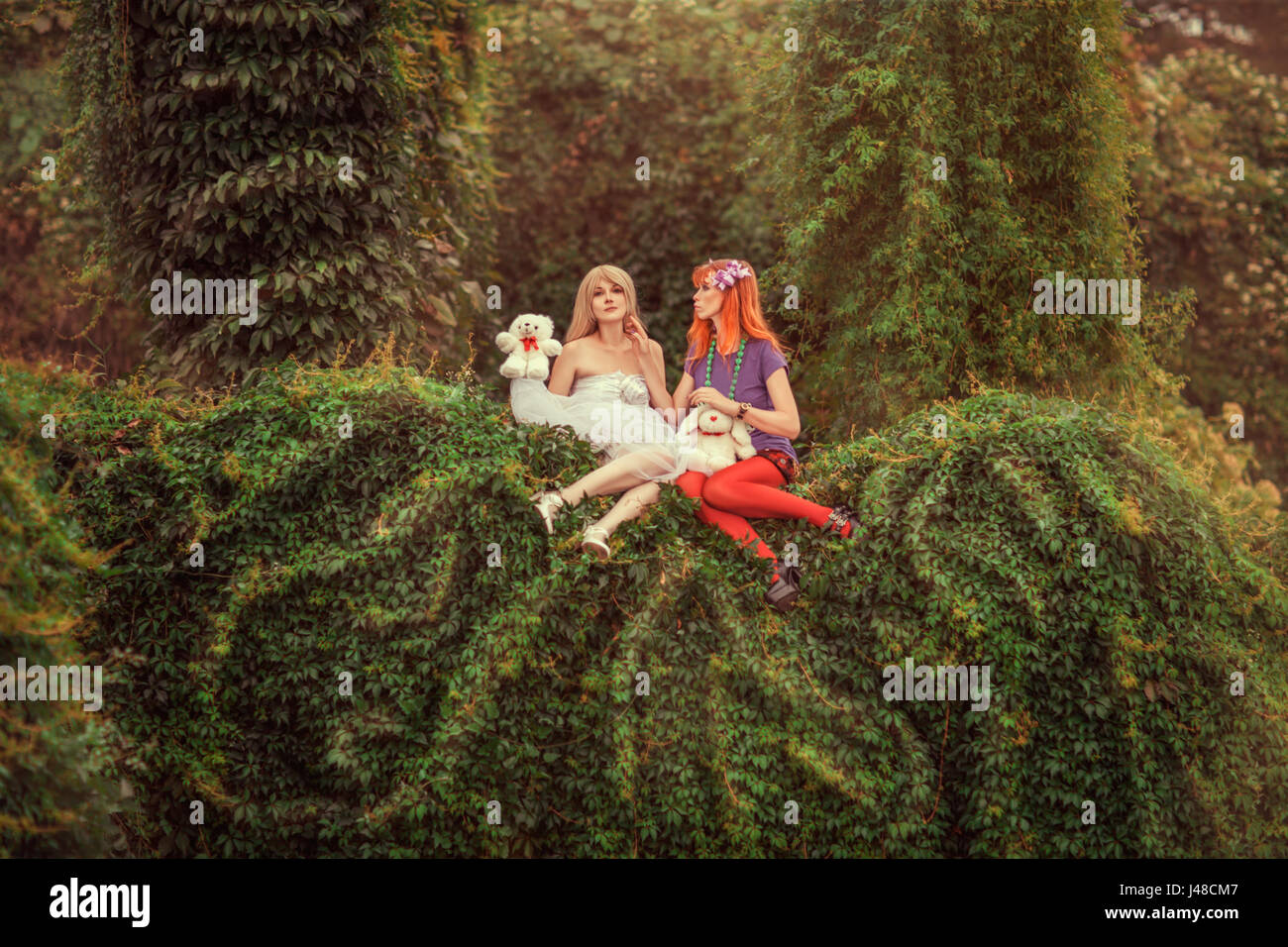 Fabulous two girls like dolls in the garden. Stock Photo