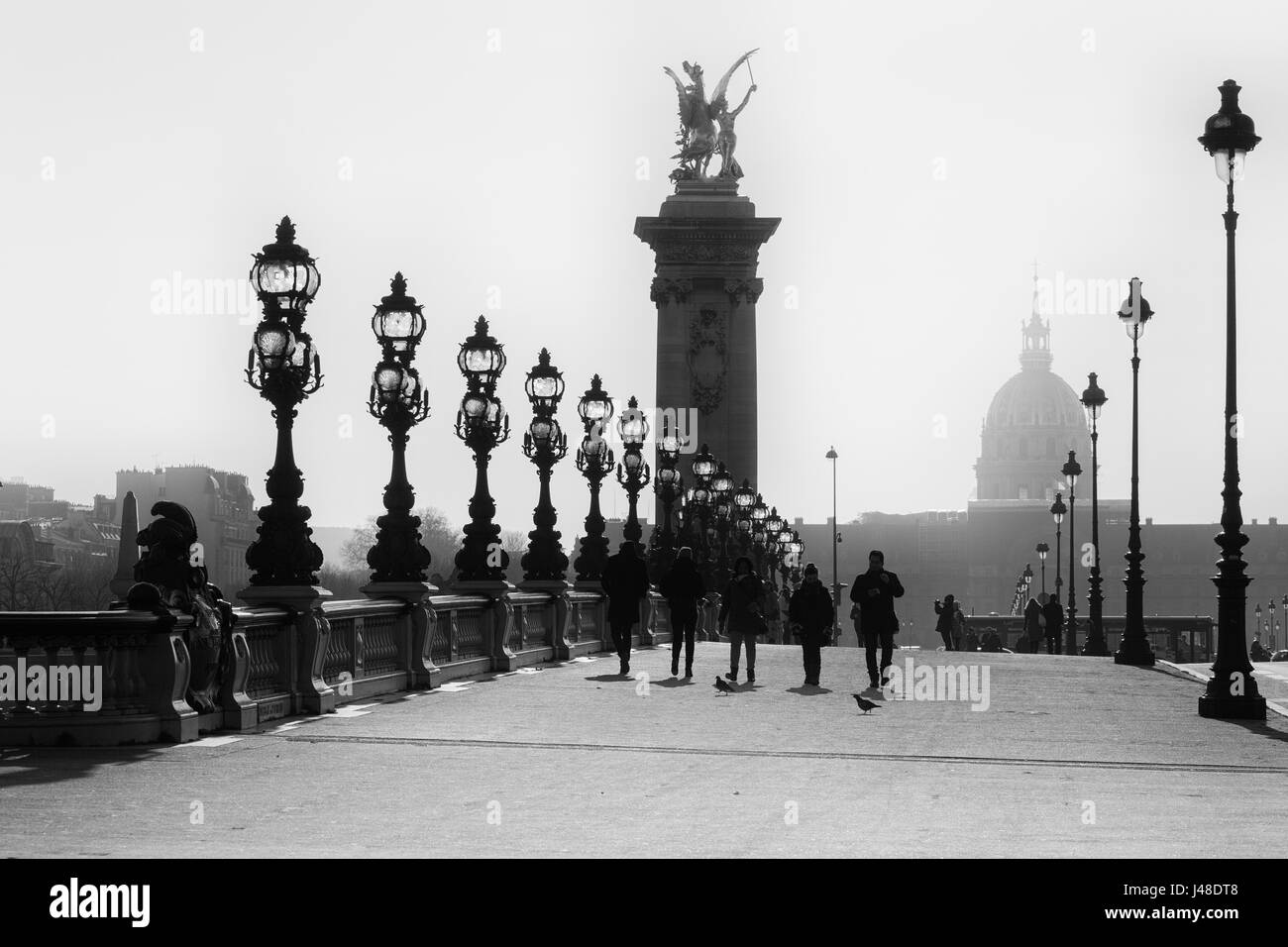 People walks on the historical Bridge Alexandre III ( Pont Alexandre III ) in Paris. Black and White image. Stock Photo