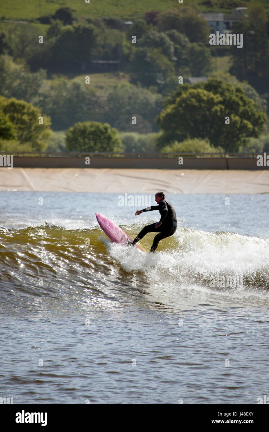 A surfer riding a wave at the artificial wave pool in the Conwy Valley
