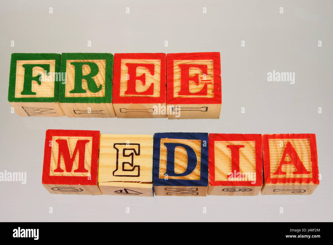 The phrase free media displayed visually on a white background using colorful wooden blocks Stock Photo
