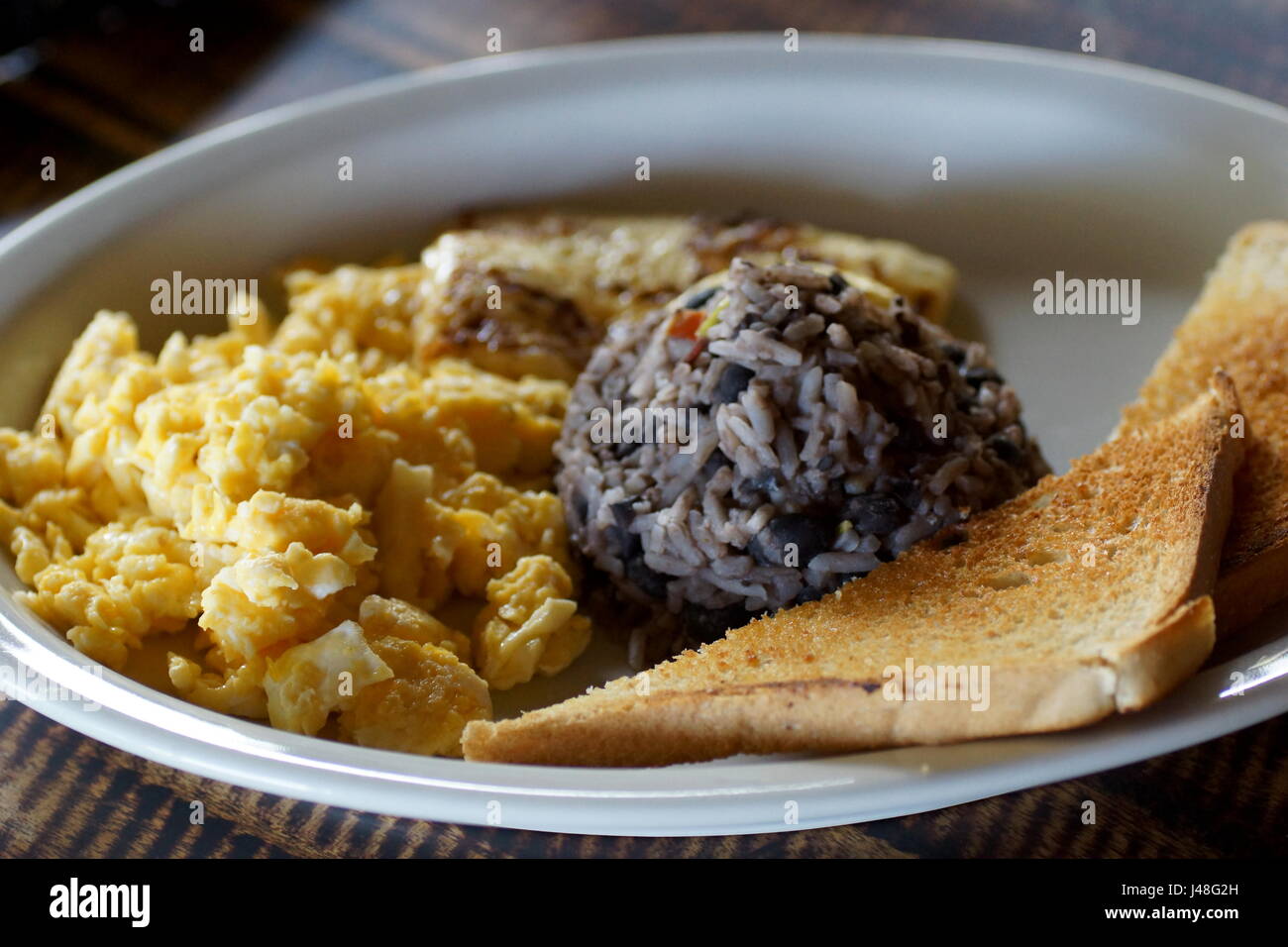 Traditional Costa Rican Breakfast. Gallo pinto with egg and toasts. Stock Photo